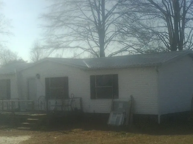 New metal roof on a white painted brick home on a foggy morning in Hot Springs